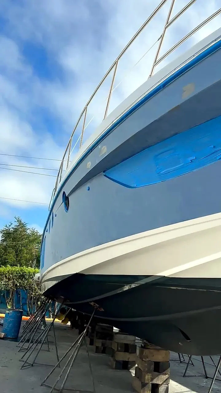 Blue-hulled motor yacht on jack stands in the boatyard