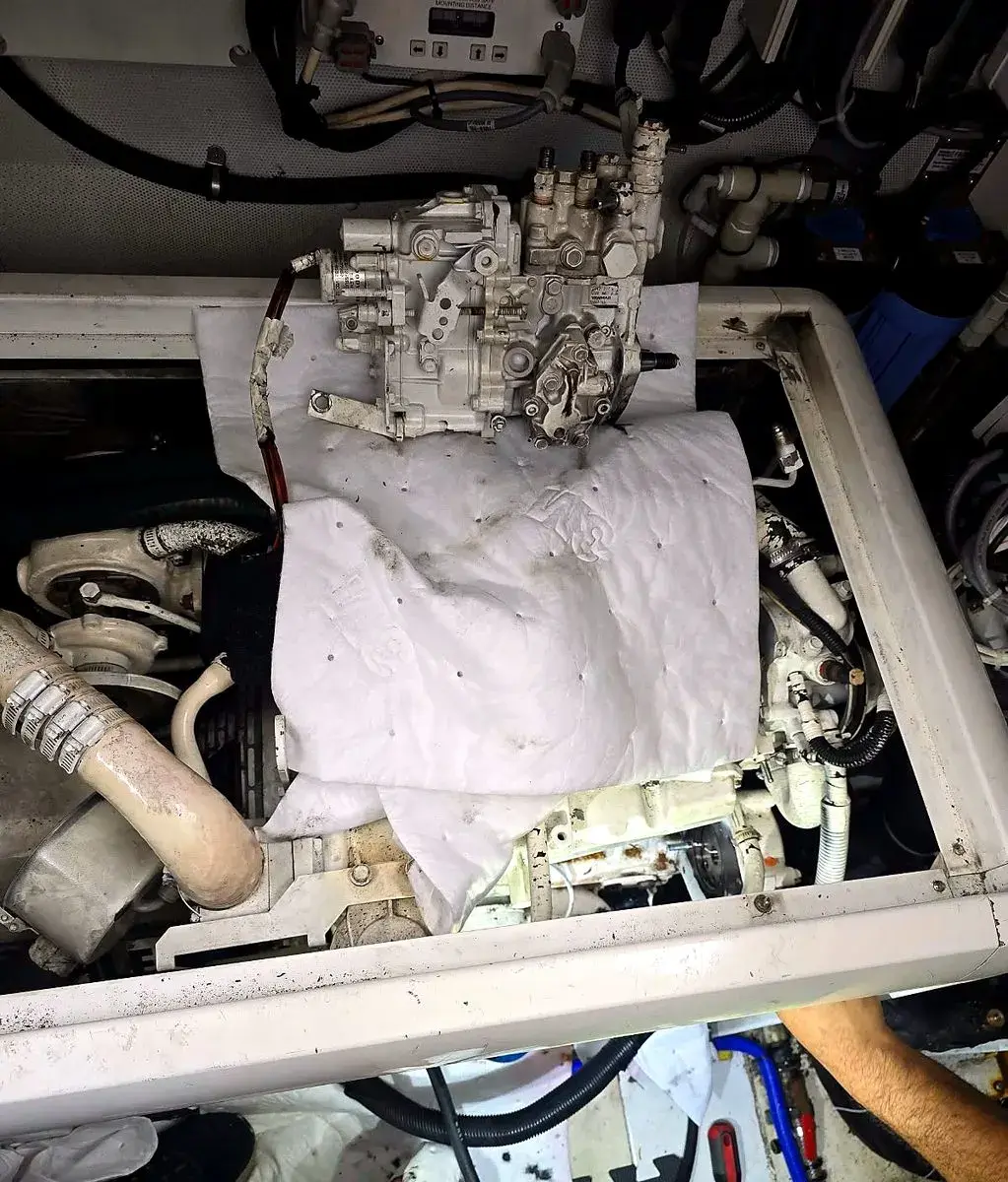 Technician removing a diesel fuel injection pump in a yacht engine room
