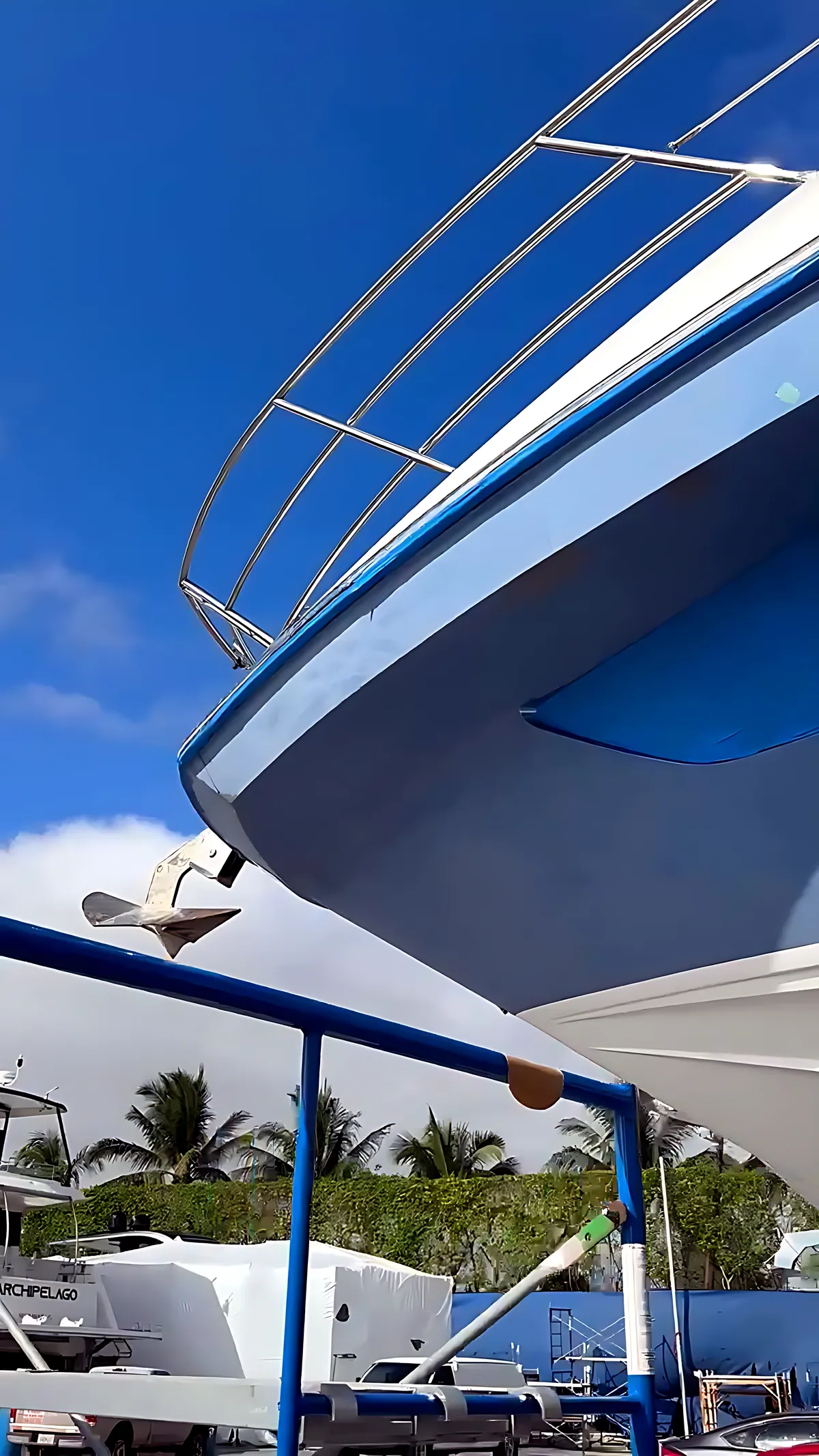 Bow of a blue motor yacht on the hard under a clear Miami sky