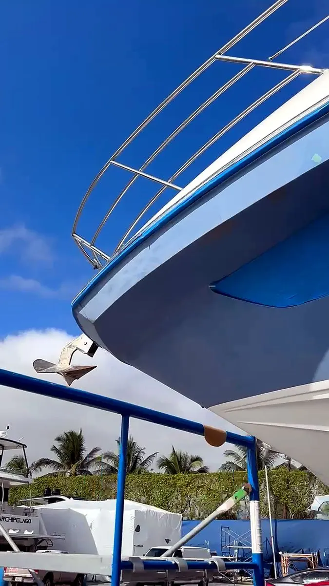 Bow of a blue motor yacht on the hard under a clear Miami sky