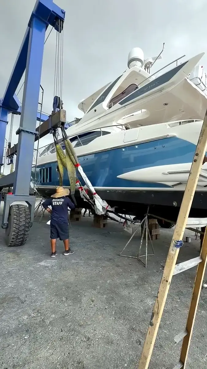 Motor yacht lifted by a travel lift during haul-out