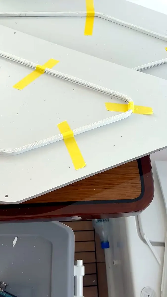 Custom-cut white panel being test-fitted aboard a yacht